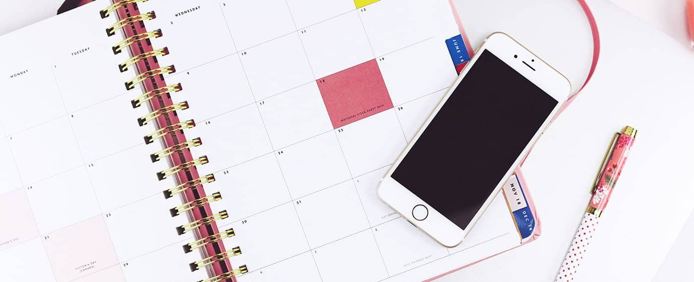 A daily planner with an iPhone lying on top