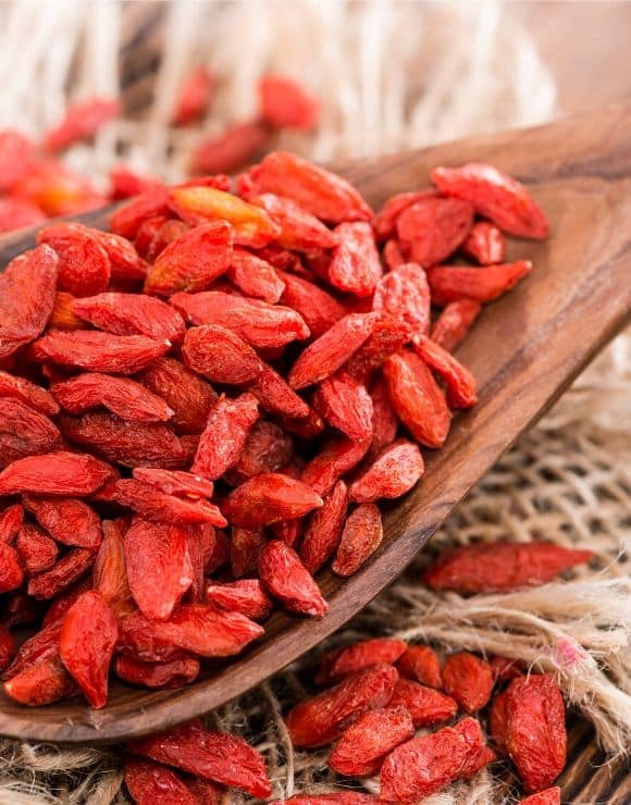 A large wooden spoonful of Goji Berries
