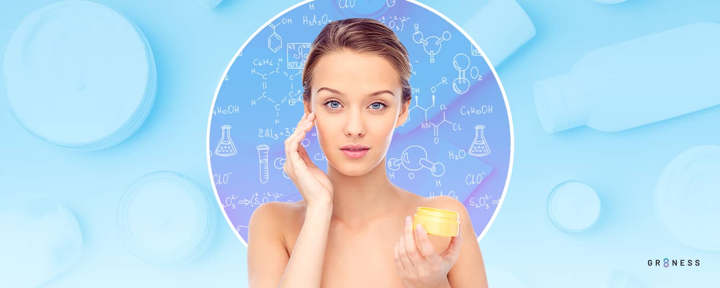 Woman applying skincare product to face while standing in front of chemistry symbols