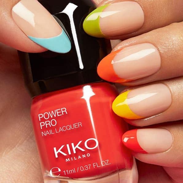 Colorful manicured nails holding a bottle of Kiko Milano Power Pro Nail Lacquer