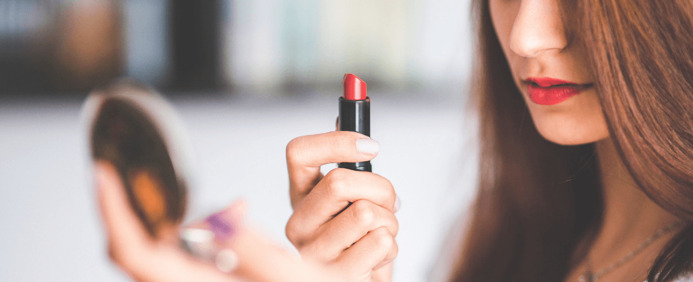 Woman carefully examining the ingredients label on her lipstick