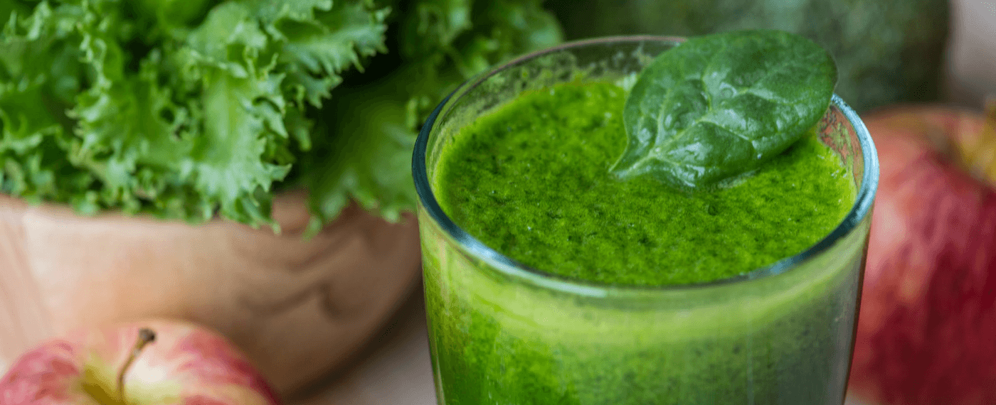 a glass of green juice for reducing bloat