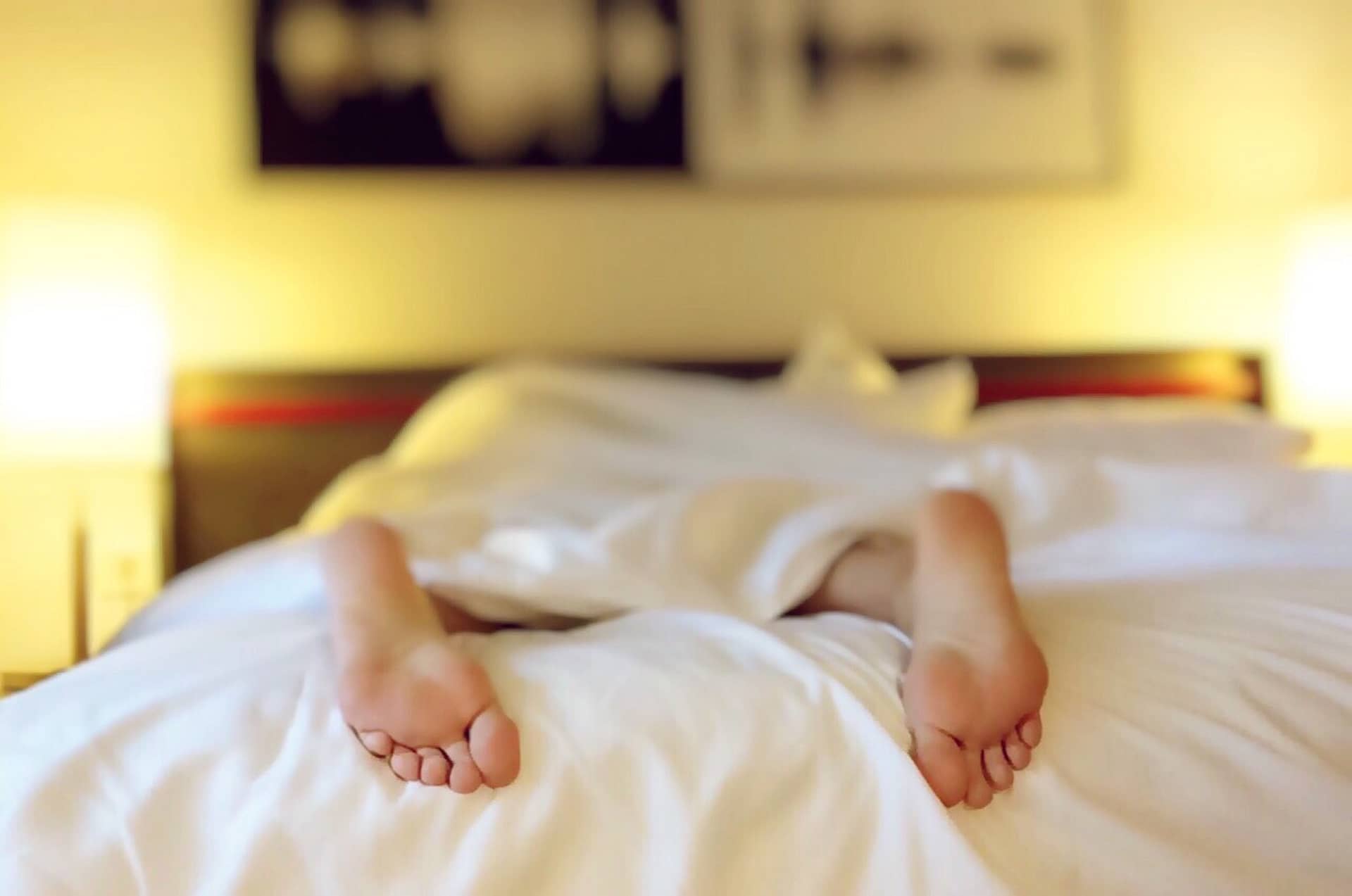 a pair of feet sticking out from the bottom of the covers