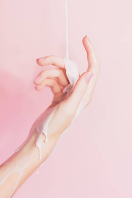 Lotion containing AHA/BHA pouring over the hand of woman