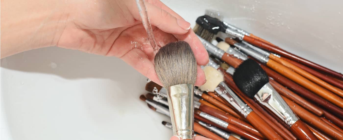 A woman cleans her makeup brushes
