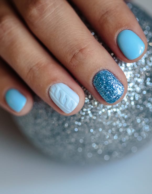 Fingernails painted in different shades and styles of blue