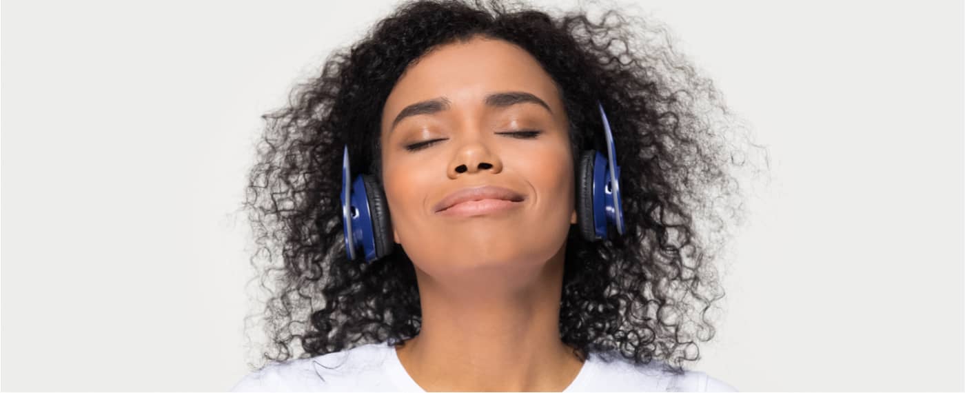 A woman with headphones finds deep relaxation through sound