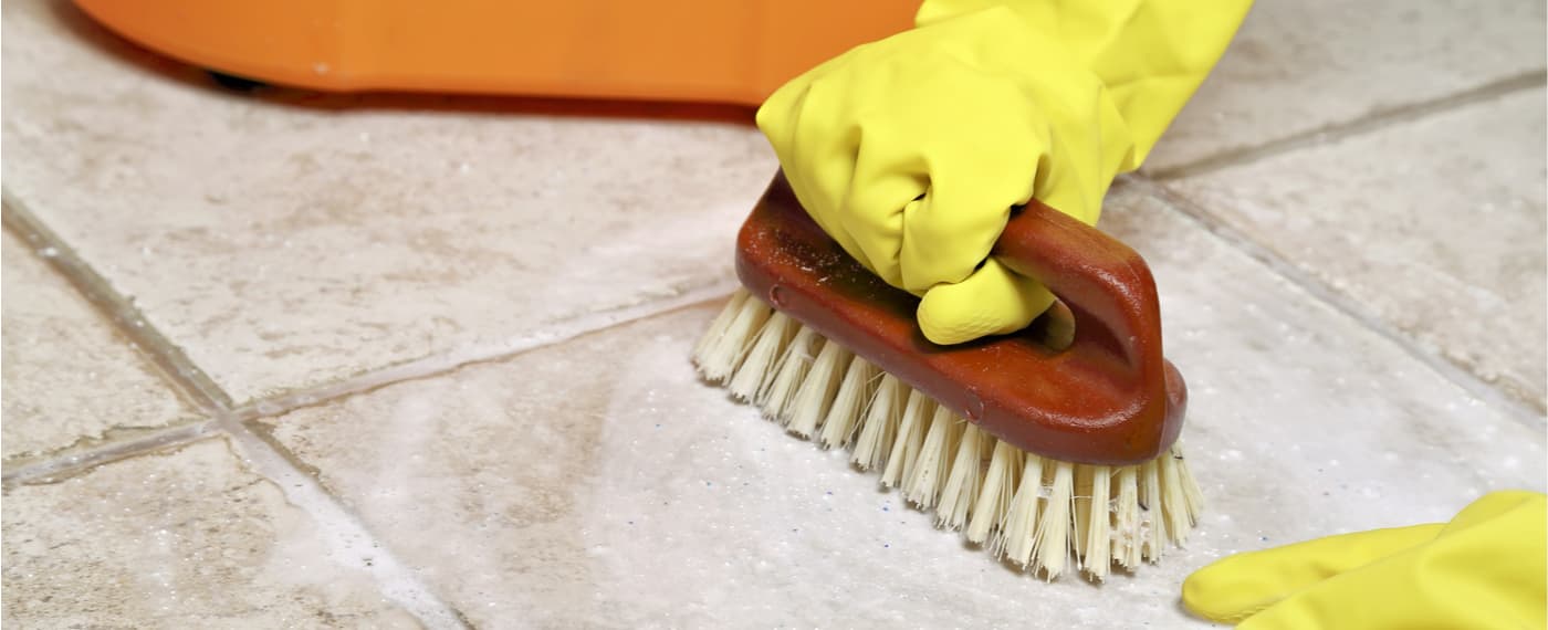 Rubber cleaning gloves using a bristle brush to scrub tile