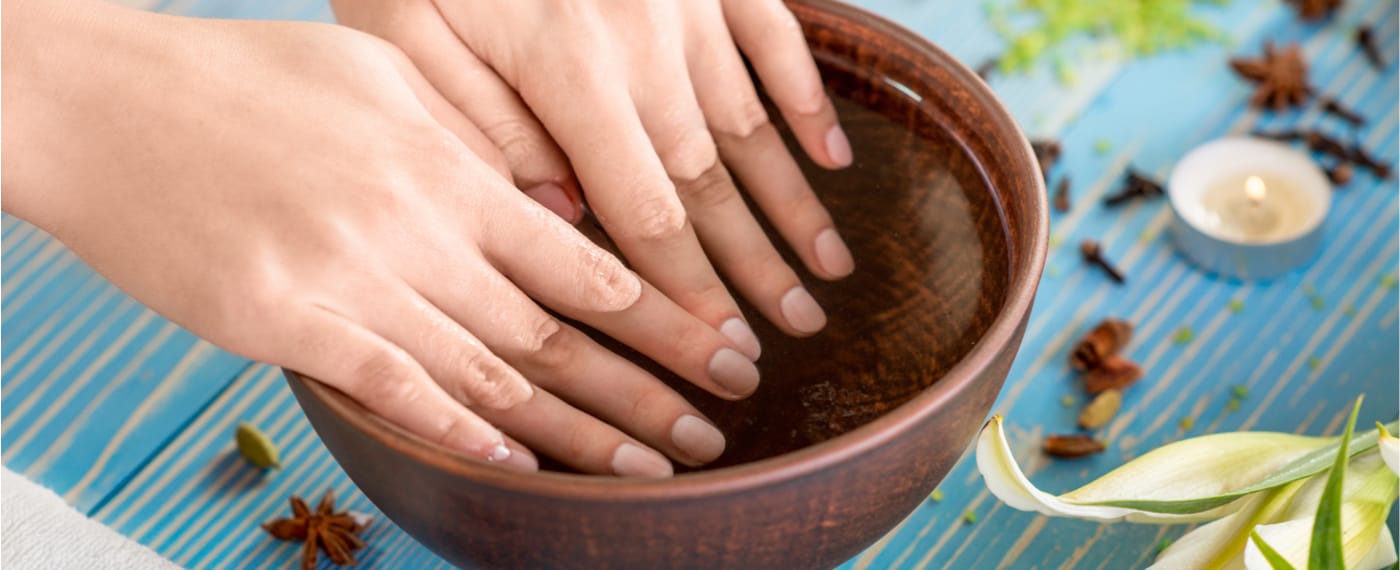 Woman using a small container as a nail care kit