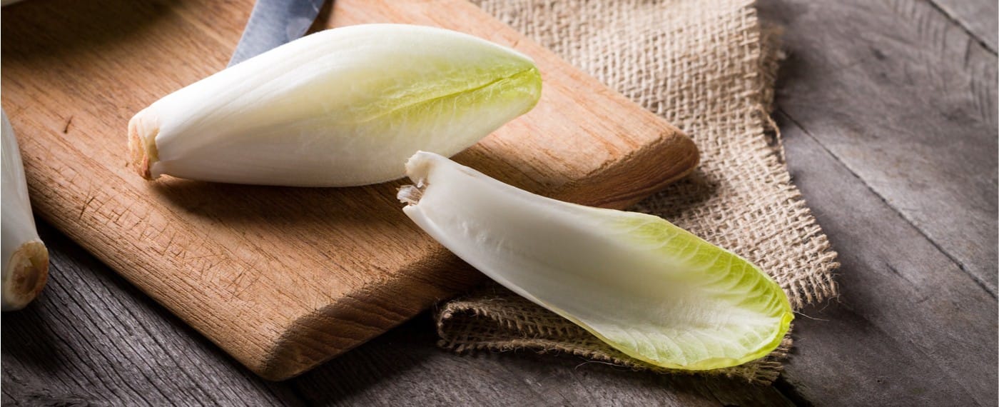 Sliced pieces of endive on a wooden cutting board