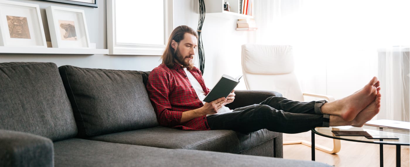 A man sits reading a book on men's health