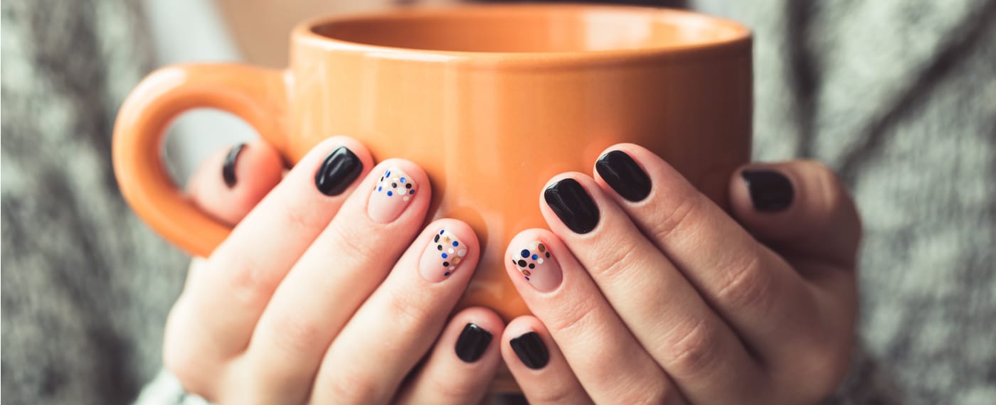 Trendy manicured nails holding a coffee mug
