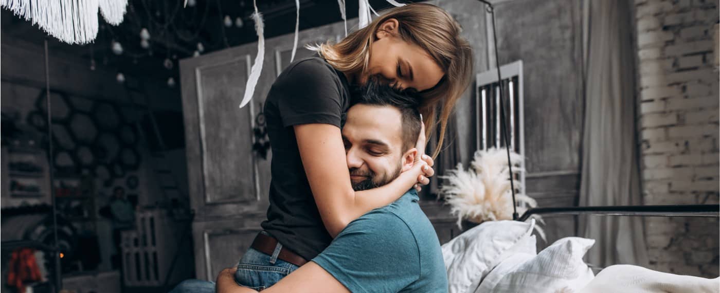 man and woman holding in each other with a strong hug