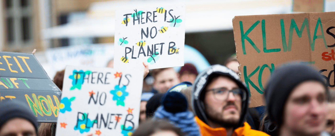 Protesters holding signs to help save the planet