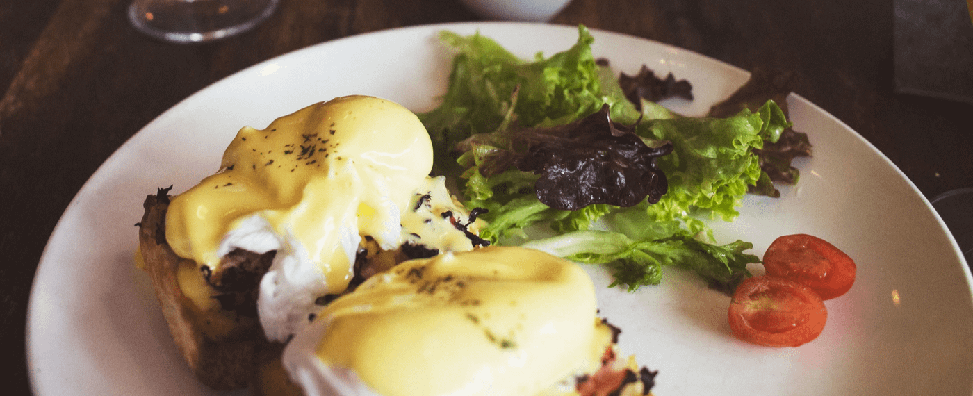 plate with eggs benedict and salad