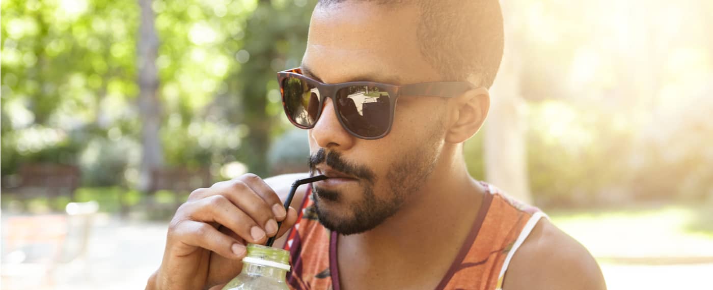 Man sipping from bottle with a straw