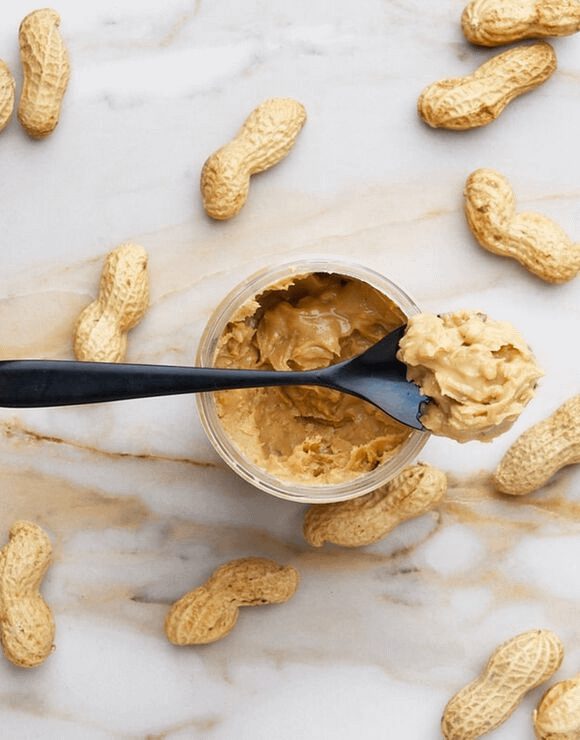 peanuts surrounding a jar of peanutbetter