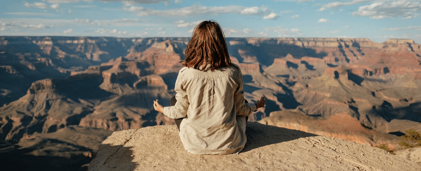 Woman meditating outside overlooking canyons