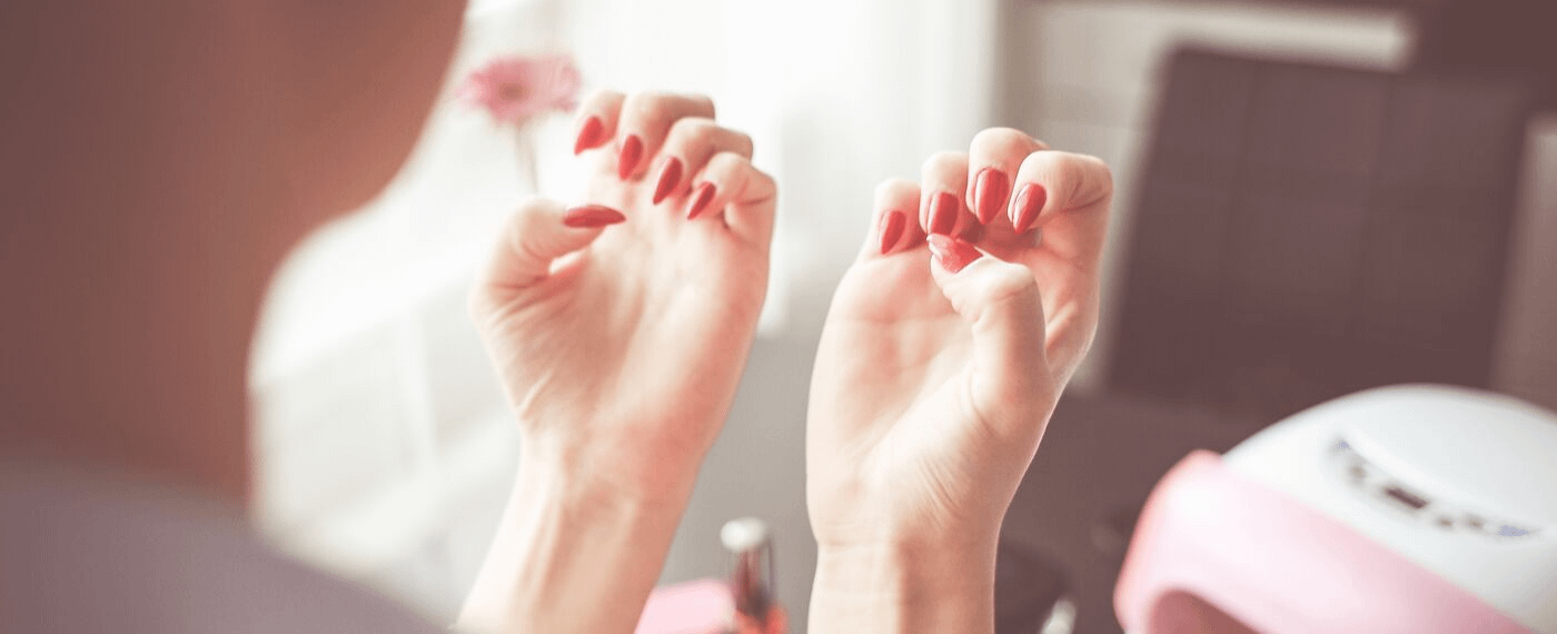 Woman's hands with long red fingernails