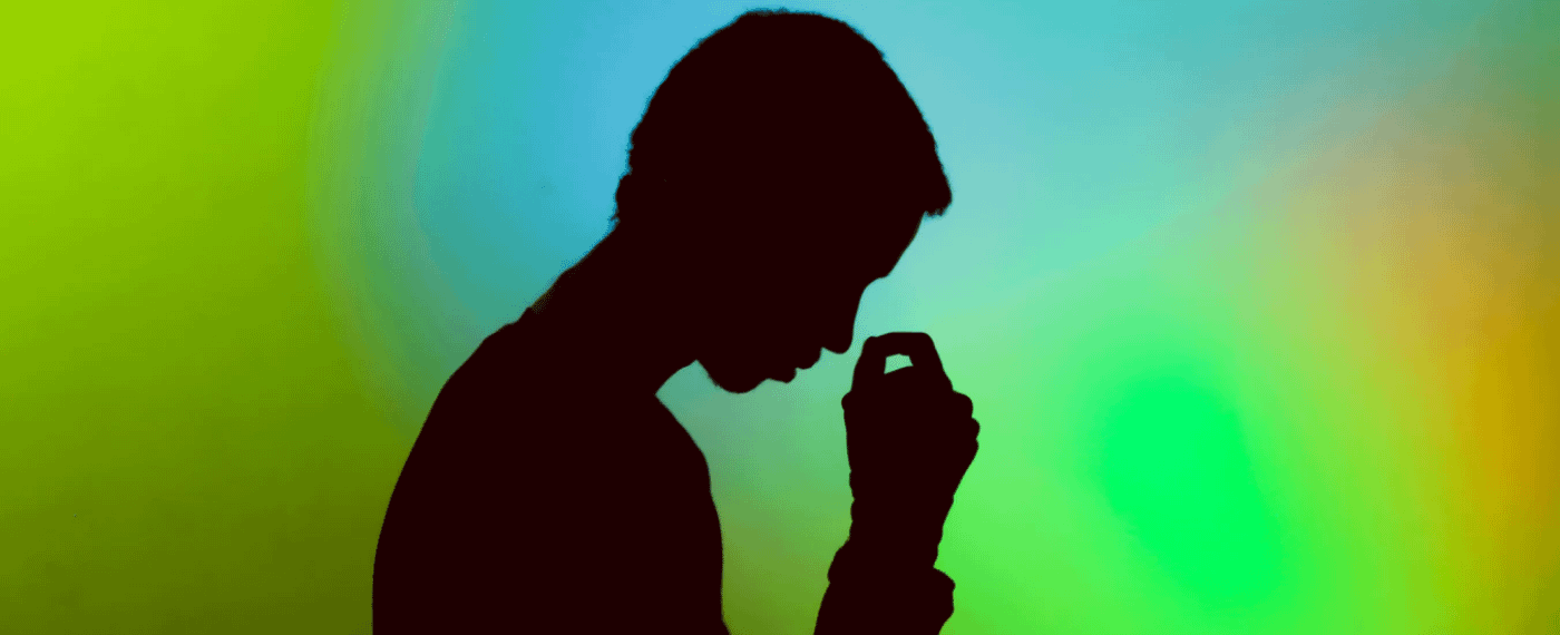 Silhouette of man against green and blue background