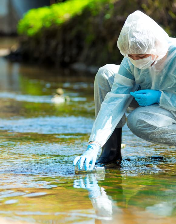 Scientist taking a sample of river water