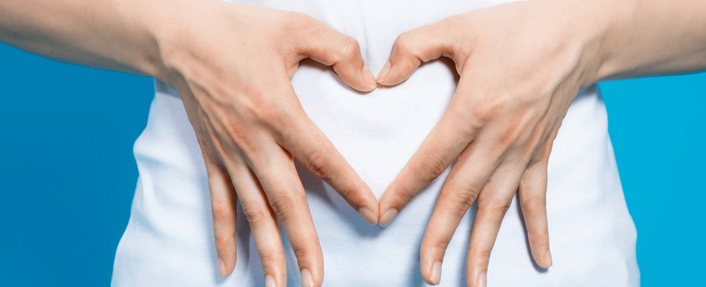 Hands forming the shape of a heart over stomach area