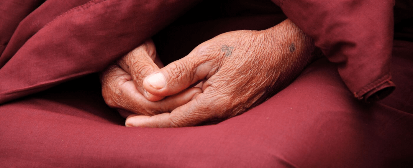 Close up of hands folded neatly in a person's lap
