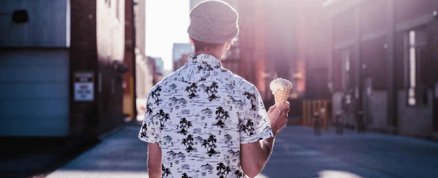 Man standing on city street holding ice cream cone