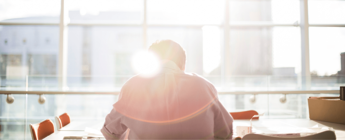 Man sitting in front of windows taking in sunlight to aid with mental health