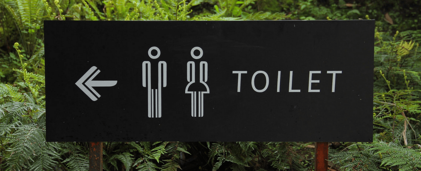 Sign pointing to restrooms due to a bad gut while traveling
