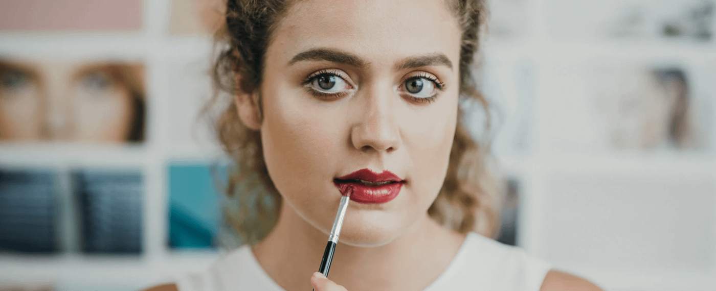 Woman applying beauty product to her lips