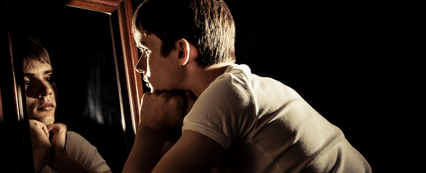 young boy staring into a mirror