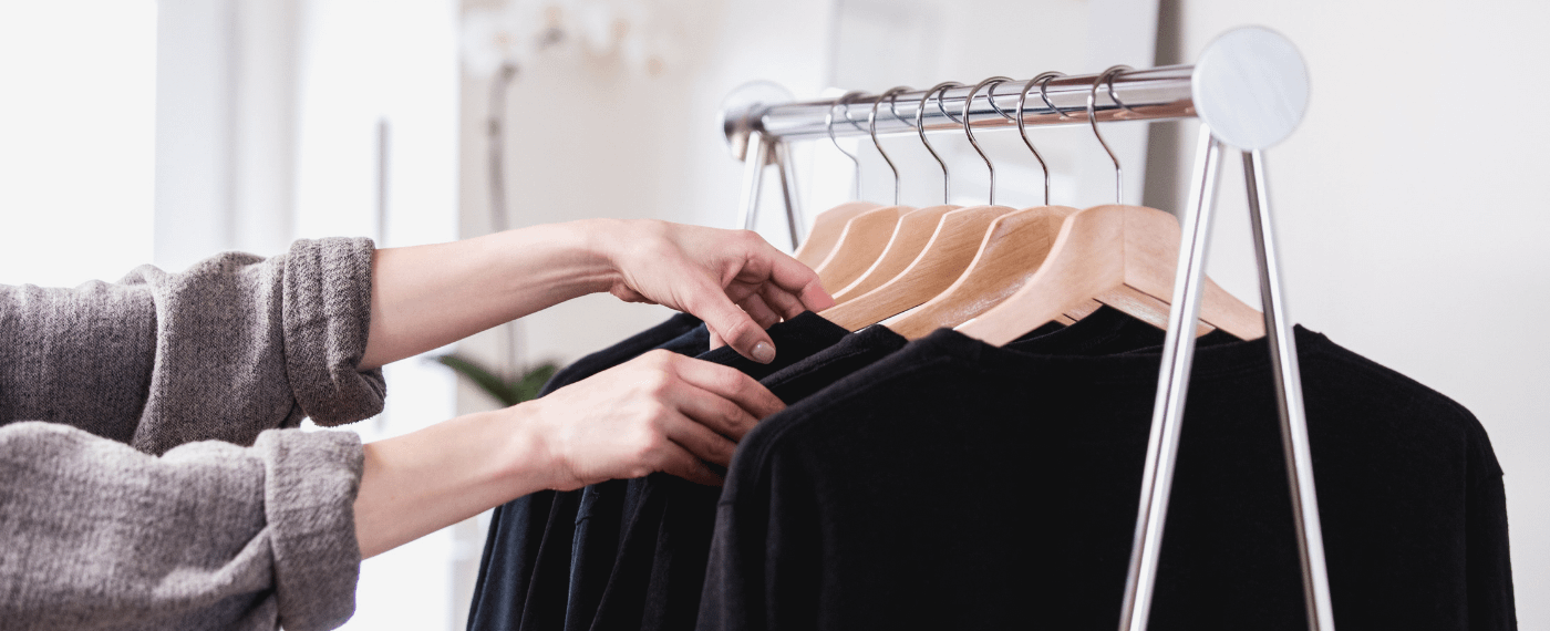 woman detoxing her closet of multiple black shirts