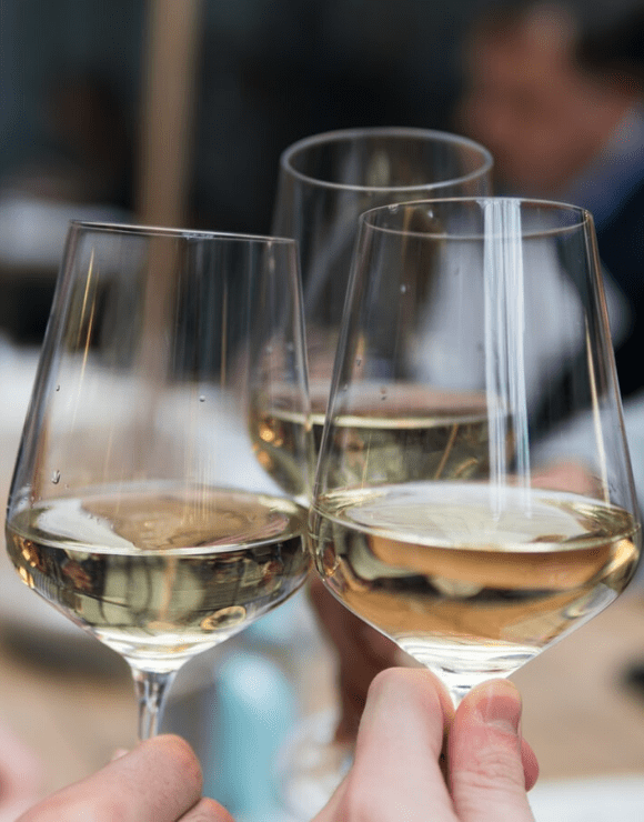 three glasses of white wine being cheered