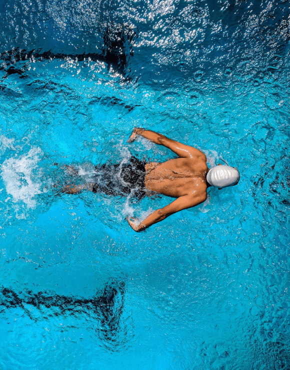 Athletic swimmer breast stroking through the water