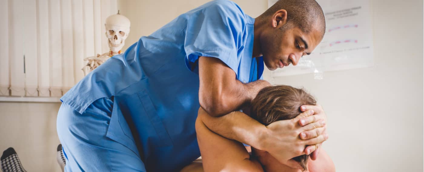 Chiropractor adjusting a patient's abdomen to help with gut health