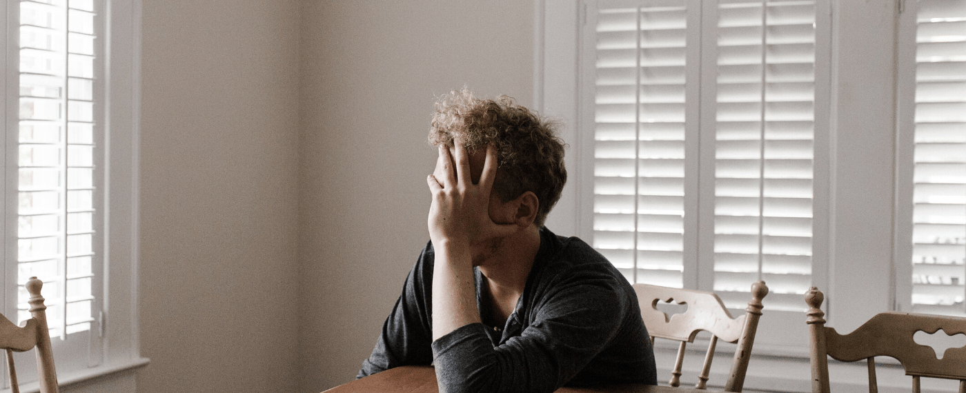 man holding face while dealing with self image issues