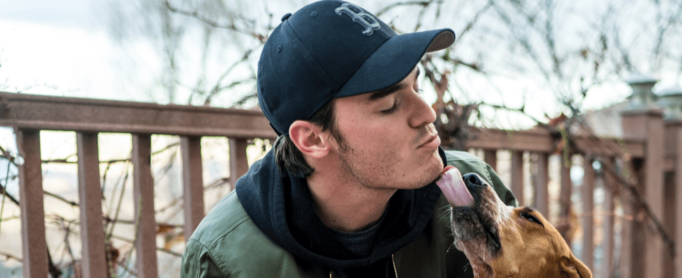 Man letting his dog kiss his face after a raw food diet