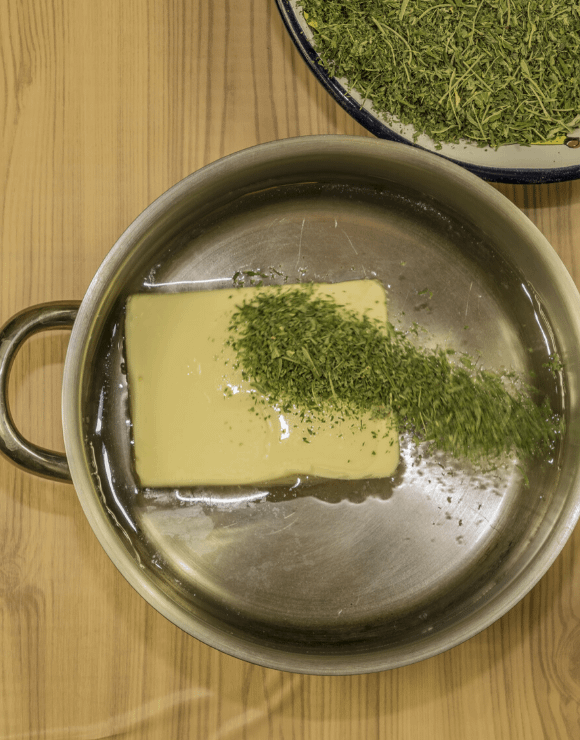 Butter melting and infusing with cannabis in a pan