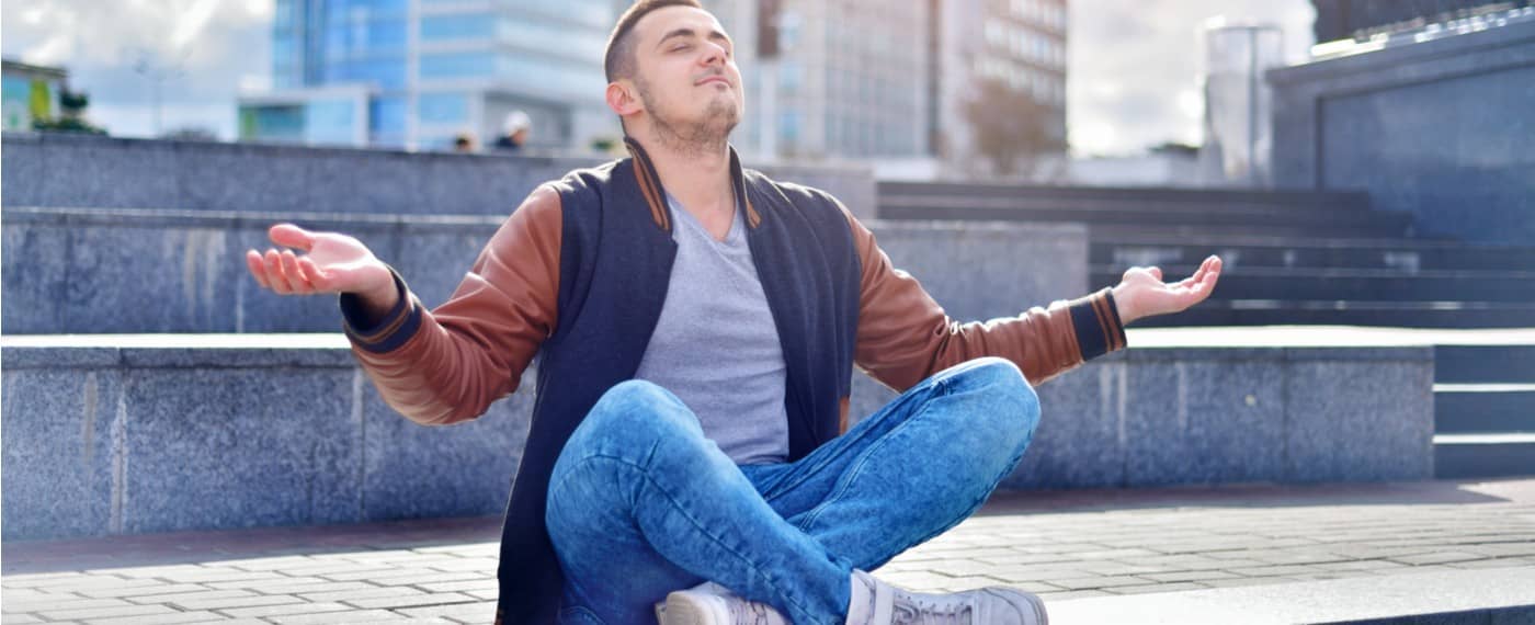 Man sitting in public practicing transcendental meditation