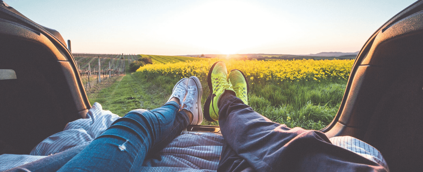 Two people practice self-care by embracing nature in an open field
