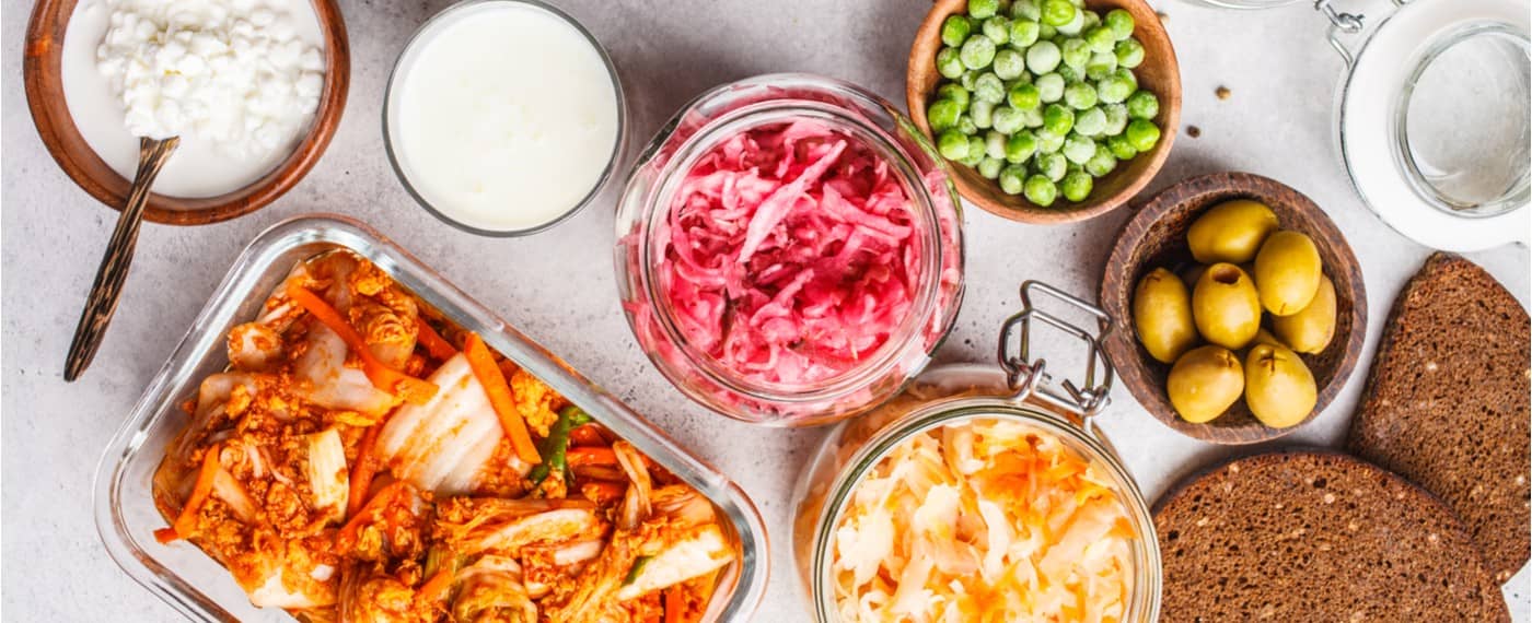 Different types of fermented foods in jars and bowls