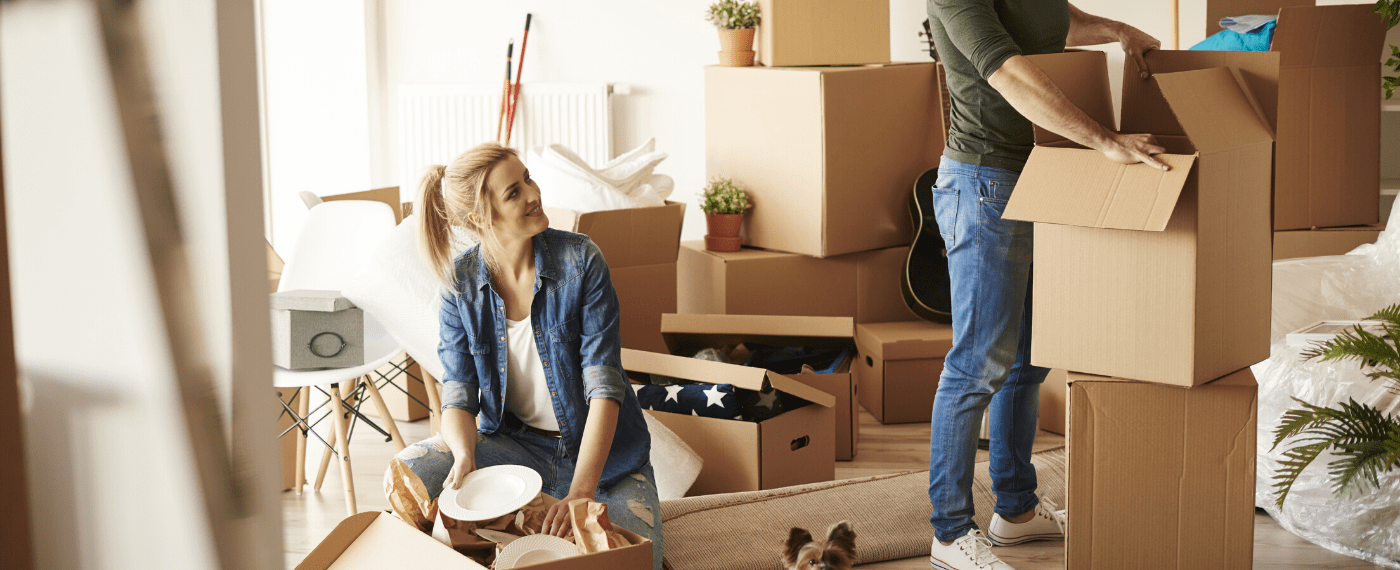 Married couple unpacking boxes after moving into a new home for the New Year
