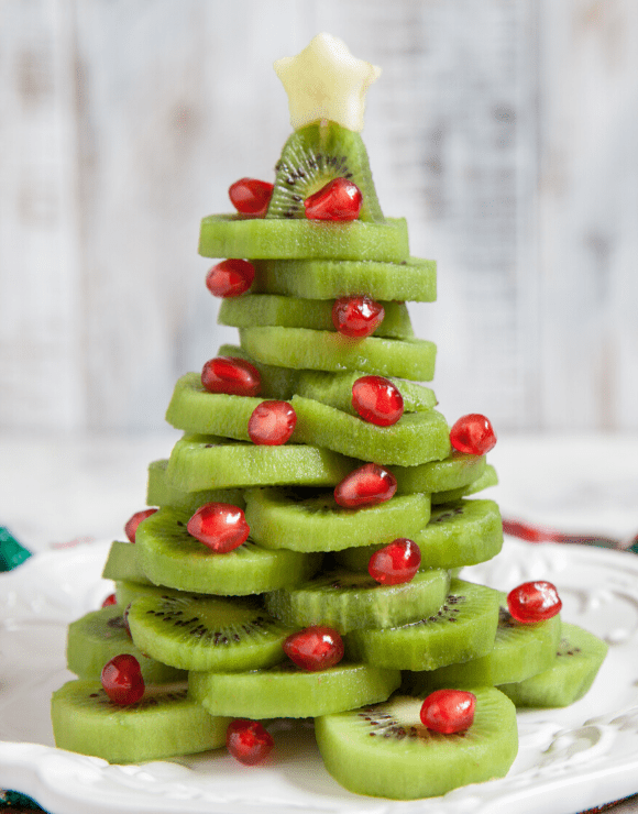 kiwi slices and cranberries arranged into a Christmas tree