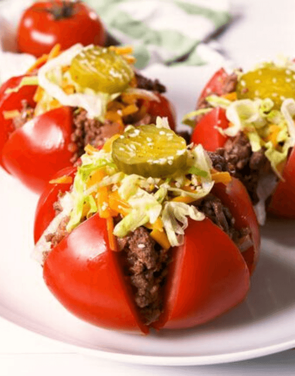 Tomato cheeseburgers with pickles on top