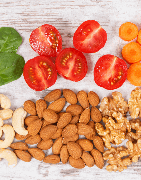 sliced tomatoes next to a pile of different healthy nuts