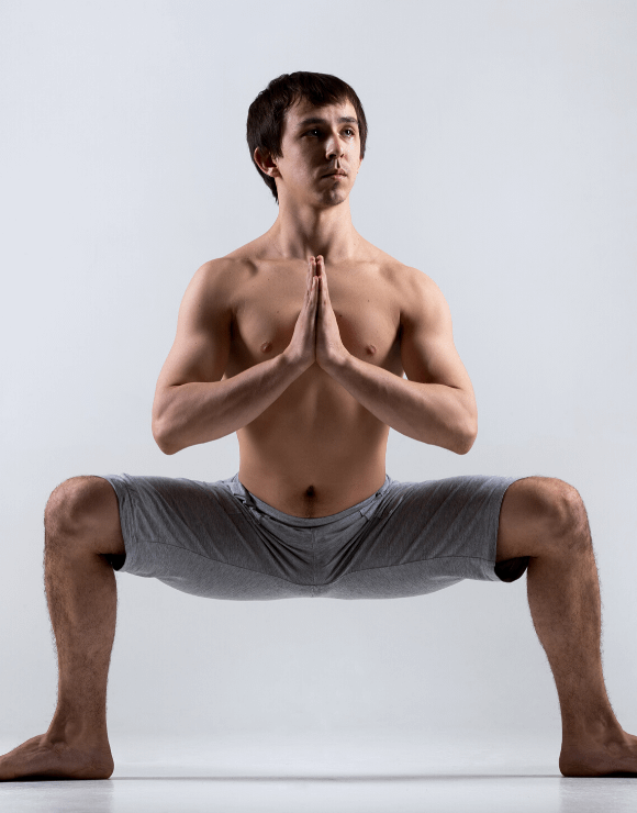 Man practicing the Yoga Squat to help stimulate his gut health