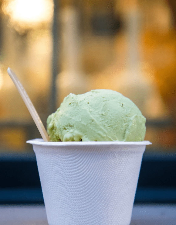 A scoop of avocado ice cream in a small cup