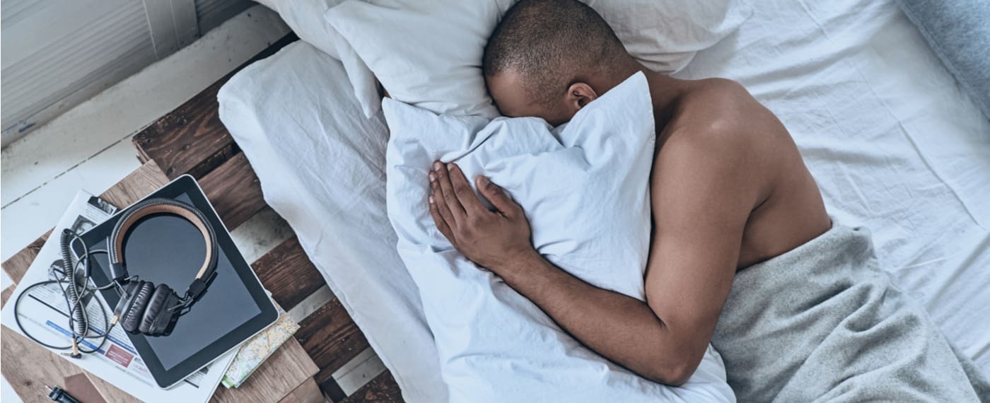 Man sleeping on his side using a body pillow