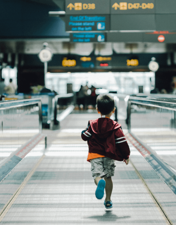 Small boy running through an airport terminal
